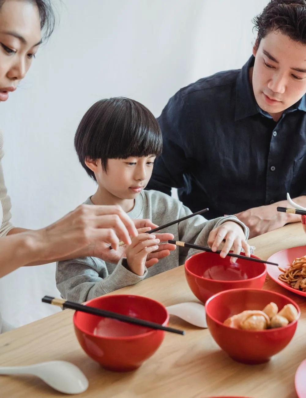 Gia đình quây quần dùng đũa gắp món trong bữa cơm